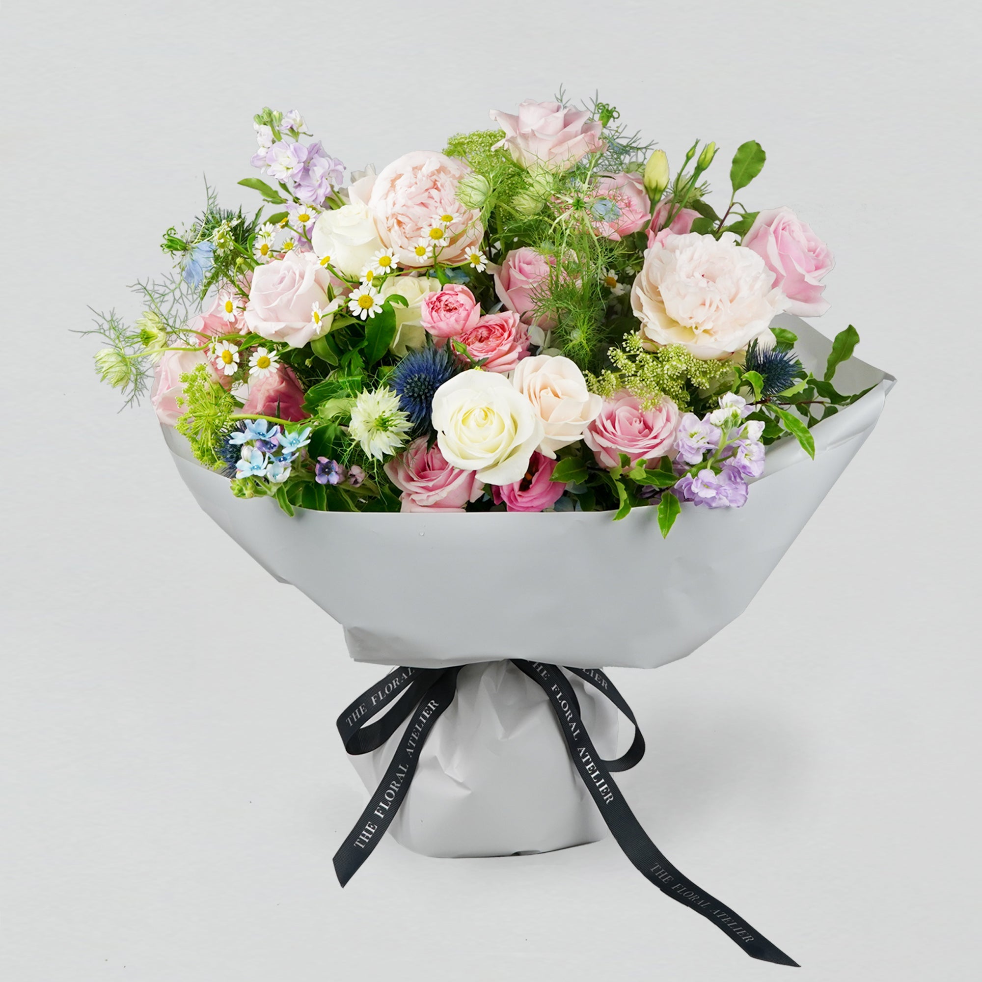 Pastel fresh florals in blue, pink and lilac, arranged in a bouquet