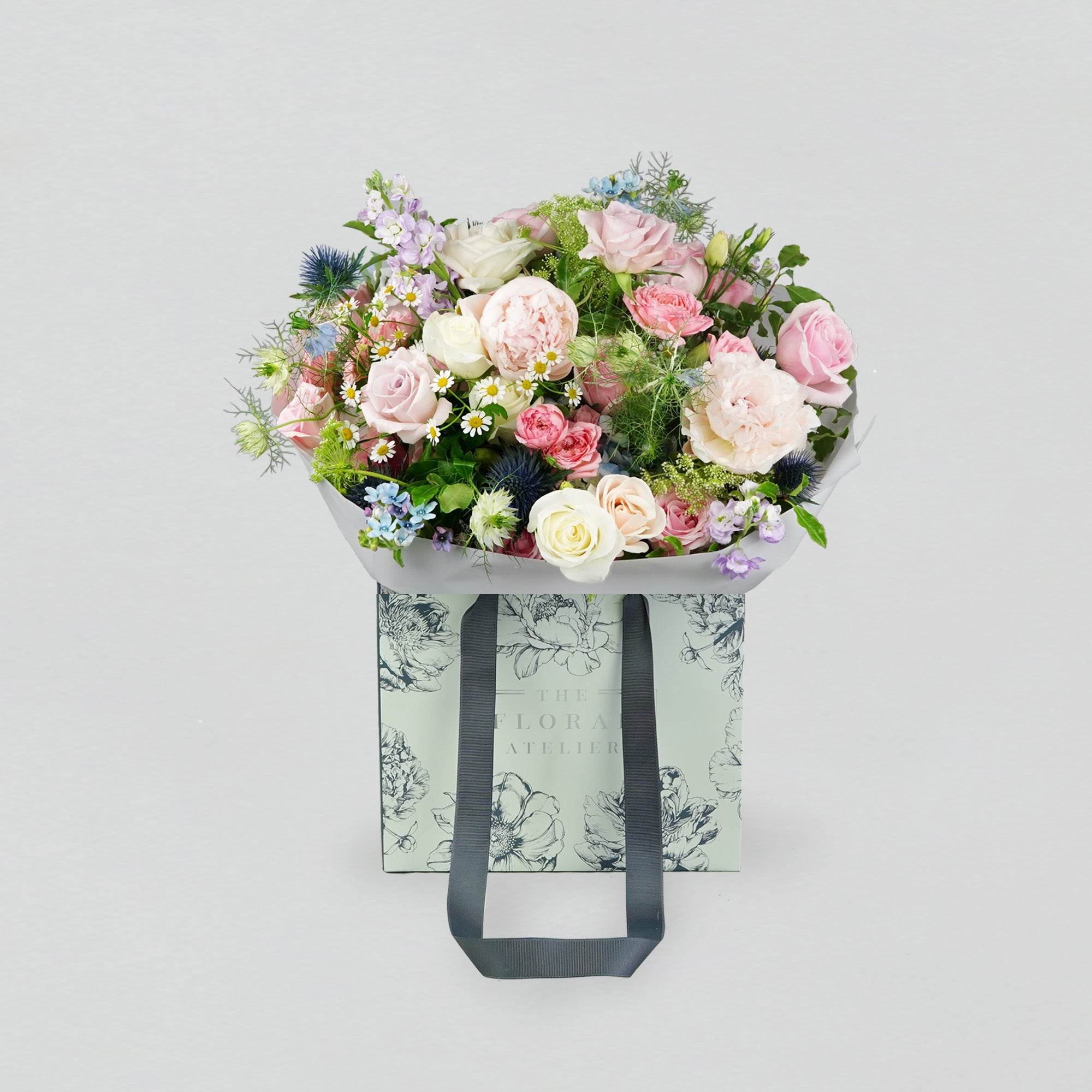 Pastel fresh florals in blue, pink and lilac, arranged in a bouquet
