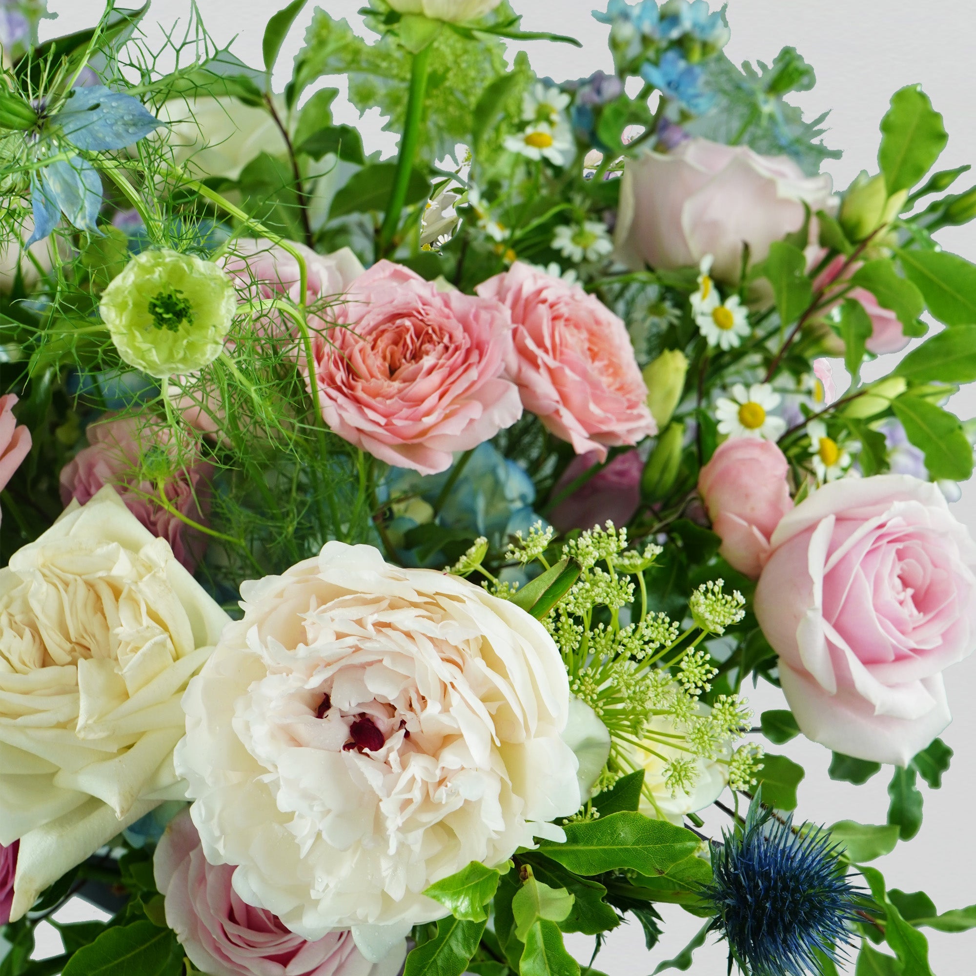 Pastel fresh florals in blue, pink and lilac, arranged in a bouquet