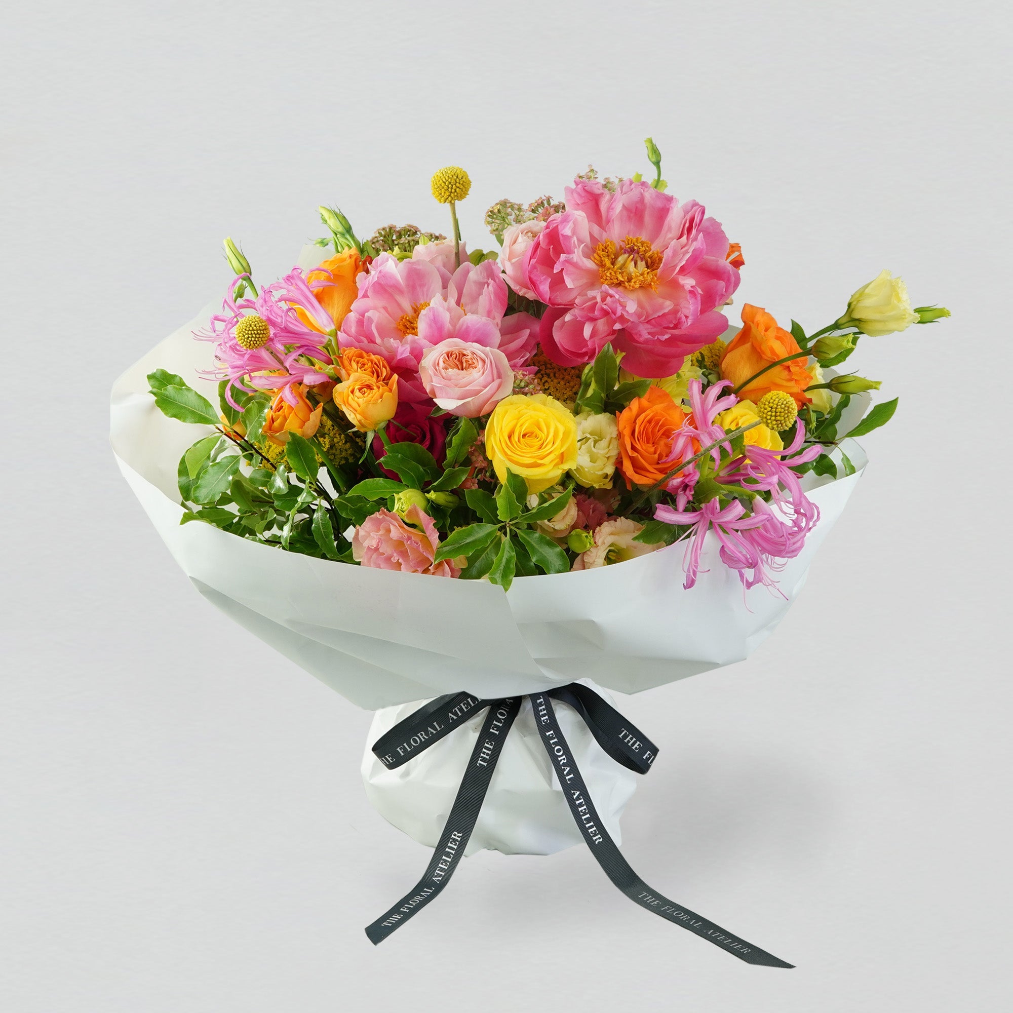 Fresh bright florals arranged into a bouquet. Featuring bright yellows, oranges and pinks. 
