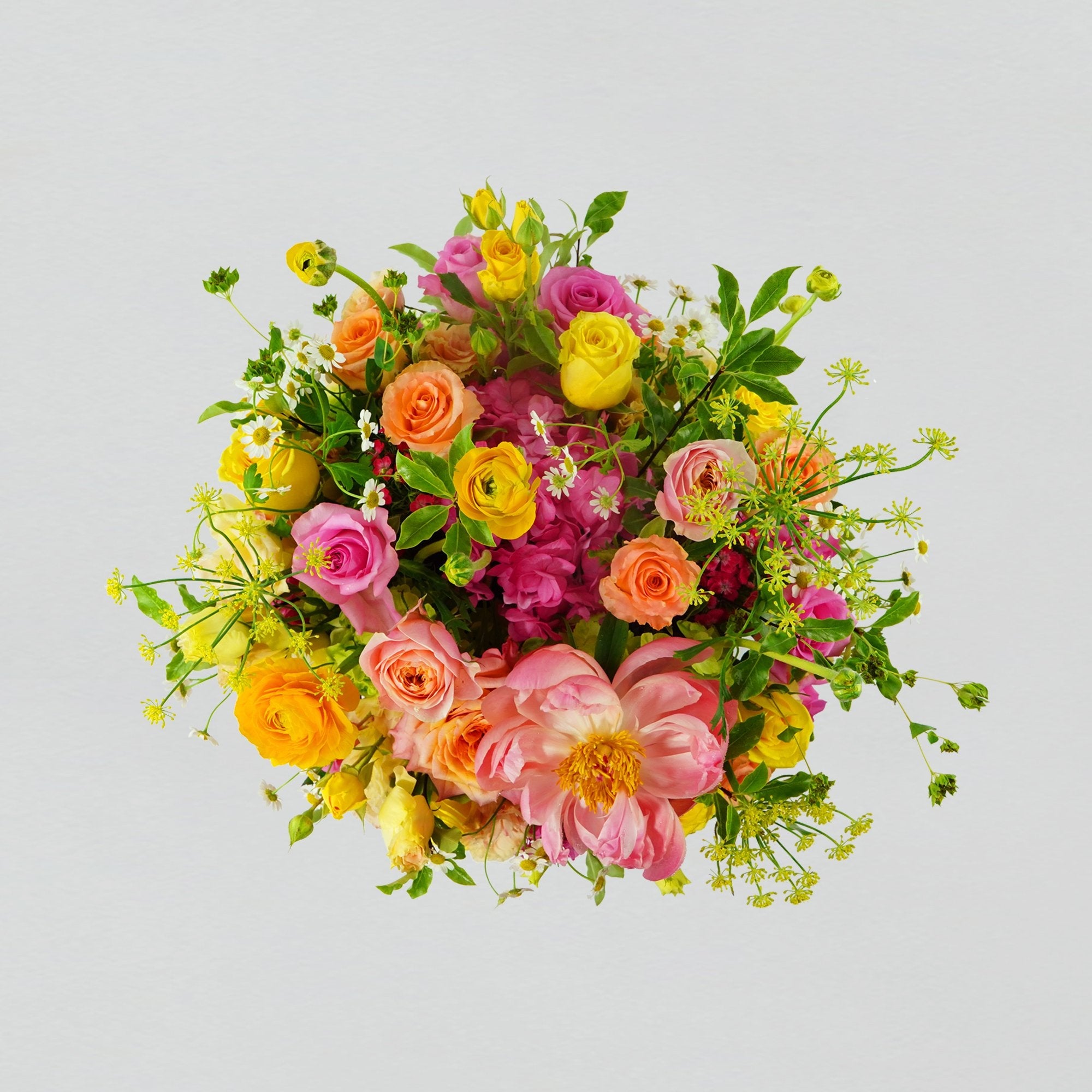 A bright selection of fresh florals arranged in a white round box