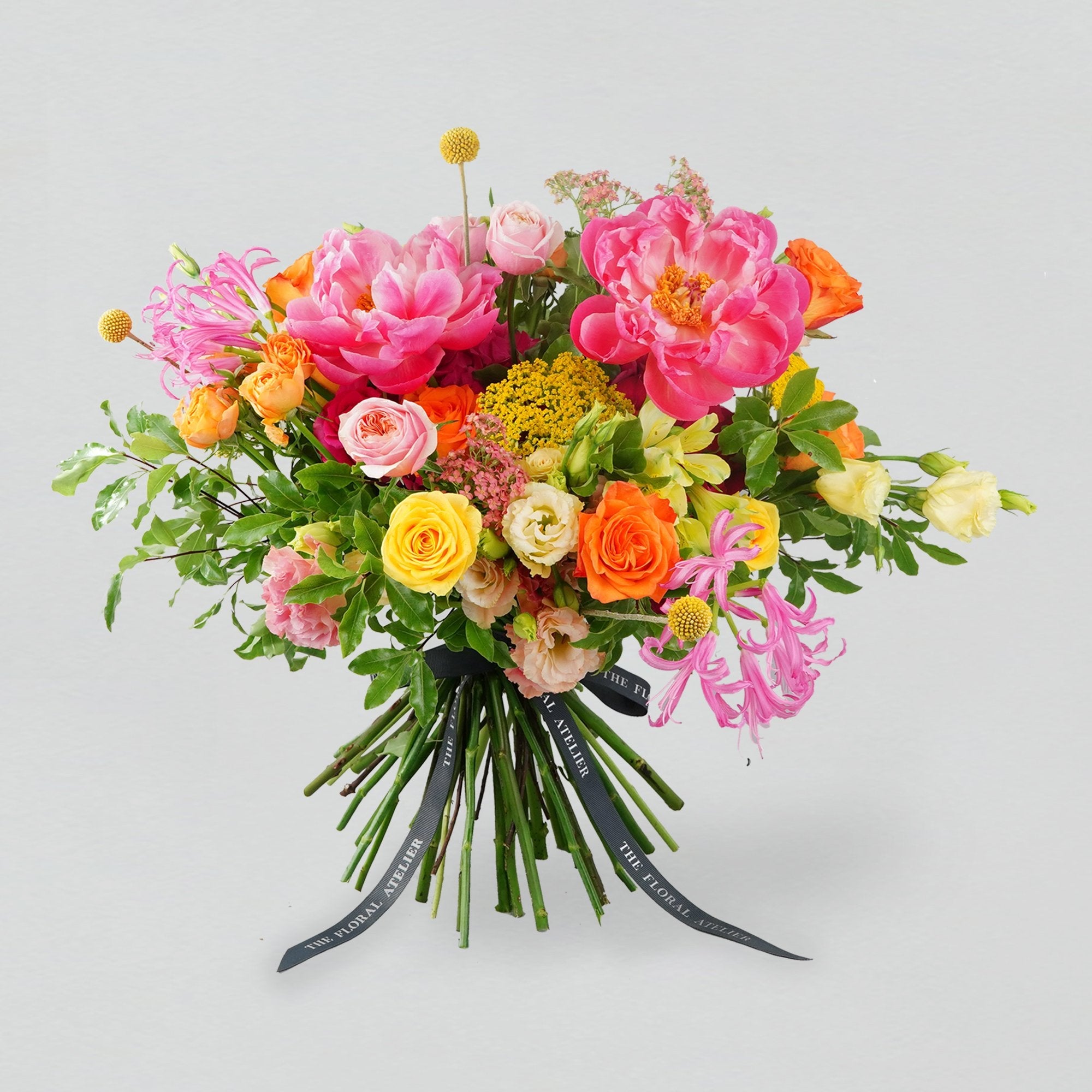 Fresh bright florals arranged into a bouquet. Featuring bright yellows, oranges and pinks. 