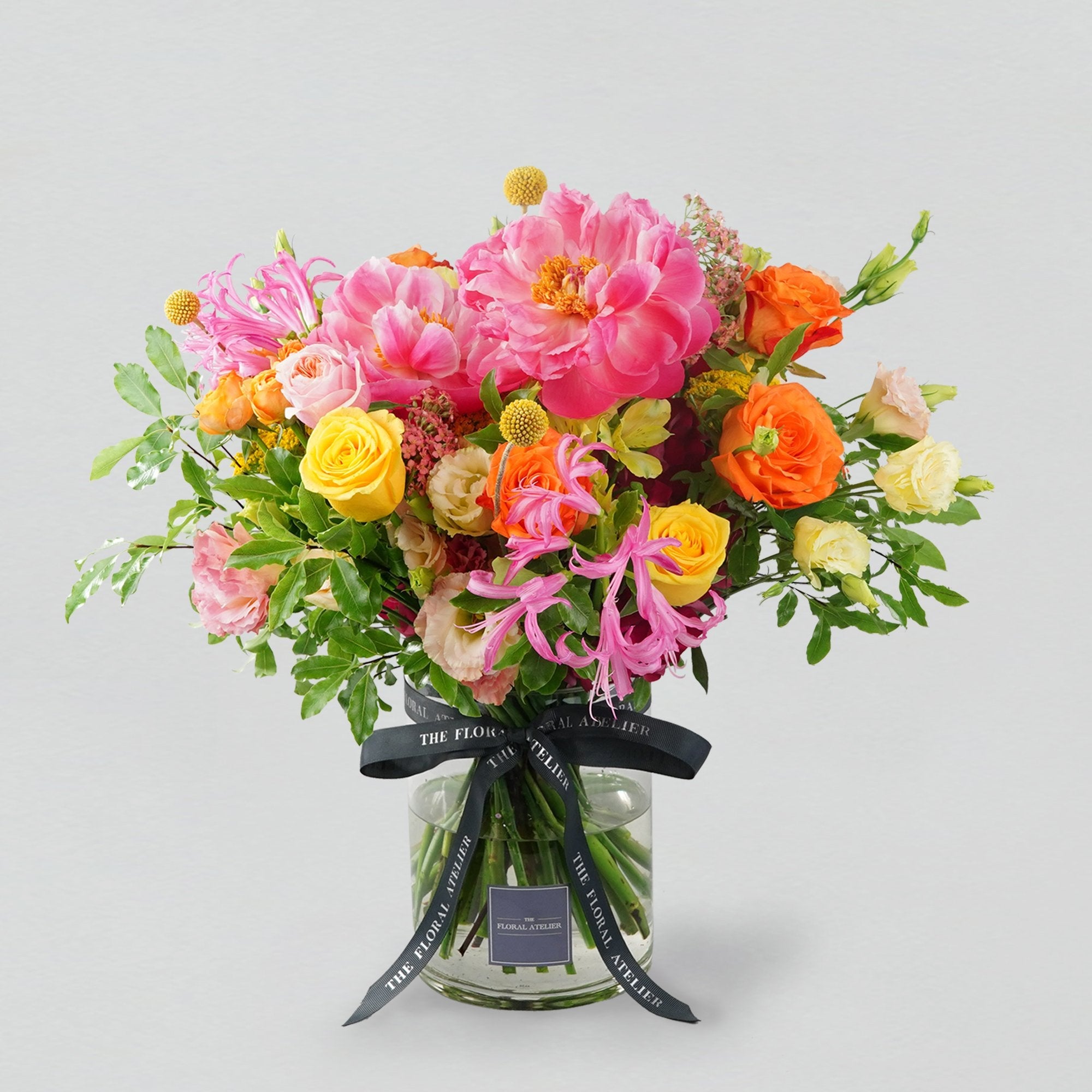 Fresh bright florals arranged into a bouquet. Featuring bright yellows, oranges and pinks. 