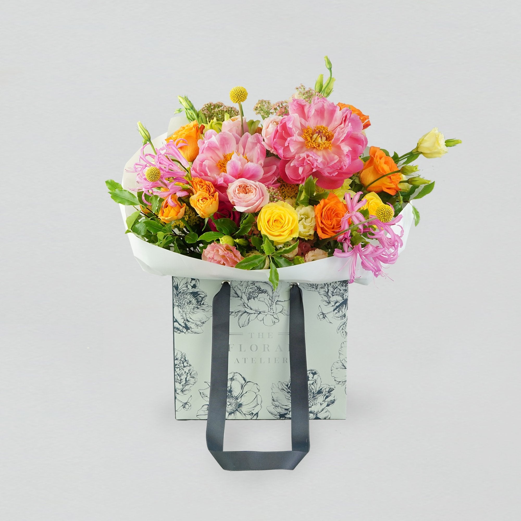 Fresh bright florals arranged into a bouquet. Featuring bright yellows, oranges and pinks. 